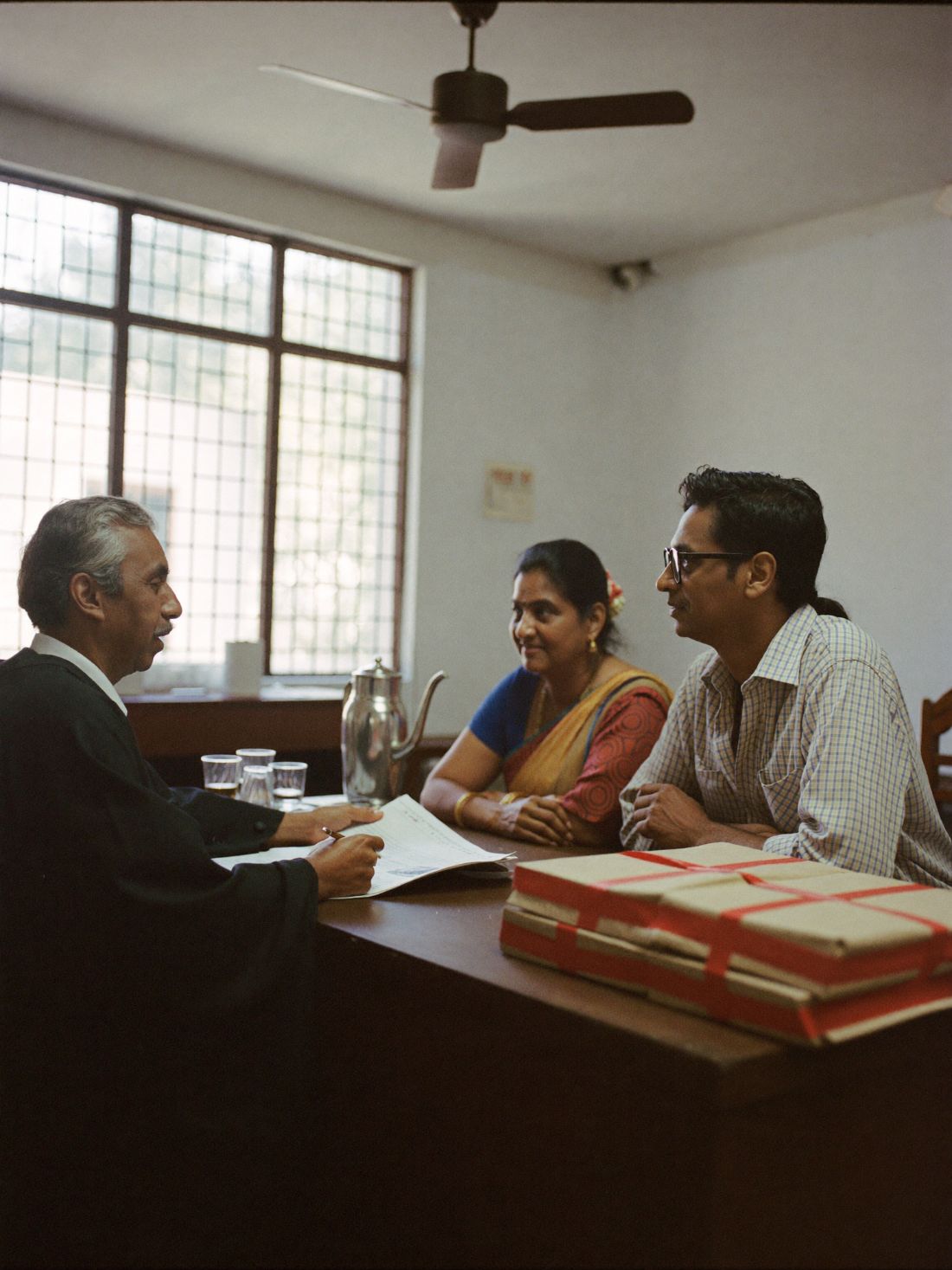 Advocate explaining divorce papers to a couple in chambers in Chennai